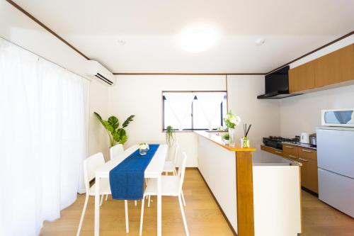 a kitchen and dining room with a table and chairs at Awaji Garden House in Shinmura in Sumoto