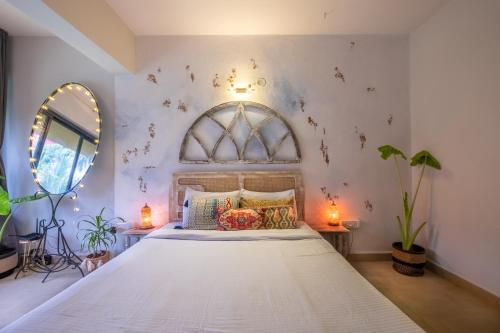 a bedroom with a large white bed with a window at La Casa - Stunning 1BHK Apartment - Vagator, Goa By StayMonkey in Vagator