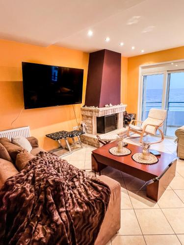 a living room with a couch and a fire place at BLUE CAVE LUXURY MAISONETTE View to the Corinthian Sea in Xylokastron