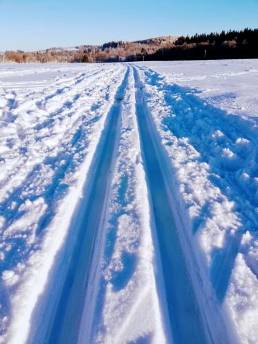 a snow trail in a field of snow at Penzion Poslední míle in Milovy