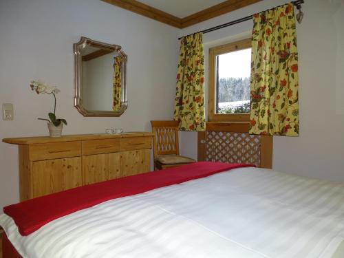a bedroom with a bed and a mirror and a window at Landhaus Feller in Reith bei Kitzbühel