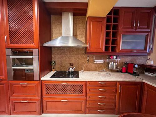 a kitchen with wooden cabinets and a stove top oven at BLUE CAVE LUXURY MAISONETTE View to the Corinthian Sea in Xylokastron