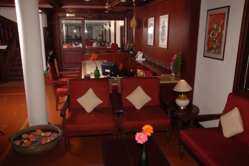 a dining room with red chairs and a table at Hotel Arches in Cochin
