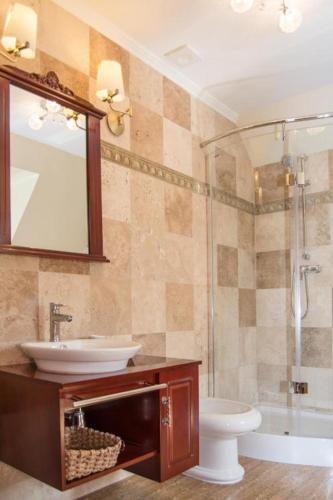 un bagno con lavandino, WC e specchio di Villa Siesta a Zielona Góra