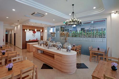 a restaurant with a bar with wooden tables and chairs at RJ Hotel Kulai in Kulai