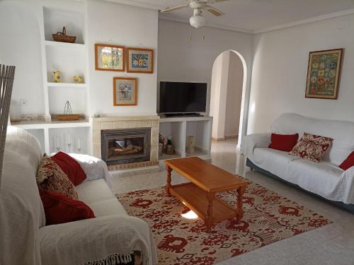 sala de estar con 2 sofás y chimenea en L'Apostille, en Mazarrón