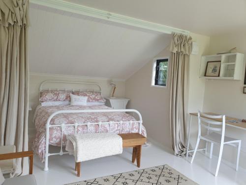 a bedroom with a bed and a table and chairs at Cabins on Tudor bed & breakfast in Motueka