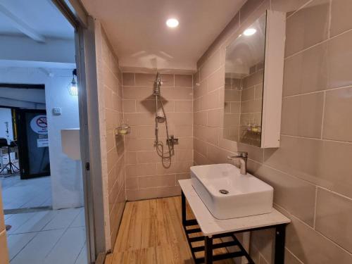 a bathroom with a sink and a shower at Kenyalang Urban Homestay in Kuching