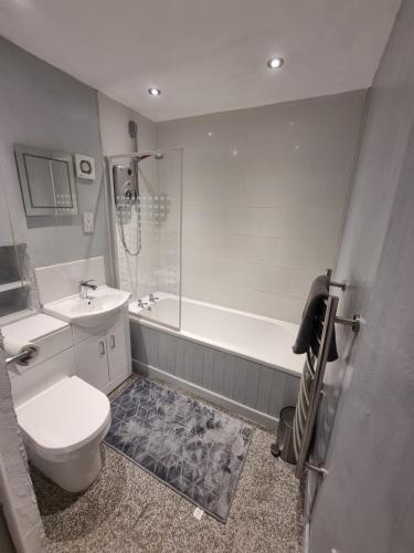 a bathroom with a toilet and a tub and a sink at Two Bedroom Barn Conversion in Newquay