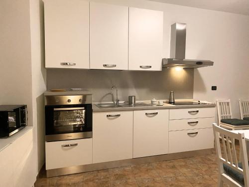 kuchnia z białymi szafkami i kuchenką w obiekcie Maison Claudio CIR VDA-AOSTA- n 0202 w Aoście