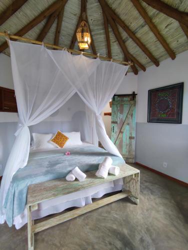 a bedroom with a bed with a canopy at Pousada Vila Cacau in Serra Grande