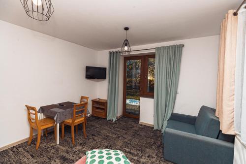 a living room with a table and a couch at Pod Śnieżnymi Kotłami in Piechowice