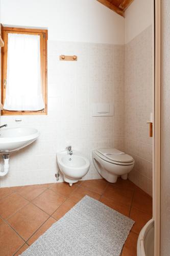 a bathroom with a toilet and a sink at Hotel Villa Rina in Bormio