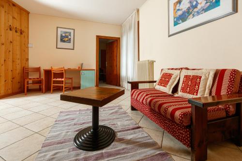 a living room with a couch and a table at Hotel Villa Rina in Bormio