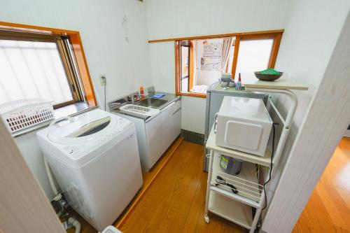 a kitchen with a sink and a washing machine at Guesthouse Maple Nikko in Nikko