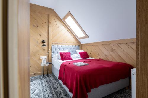 a bedroom with a large bed with a red blanket at Willa pod Orłem - Zakopane in Zakopane