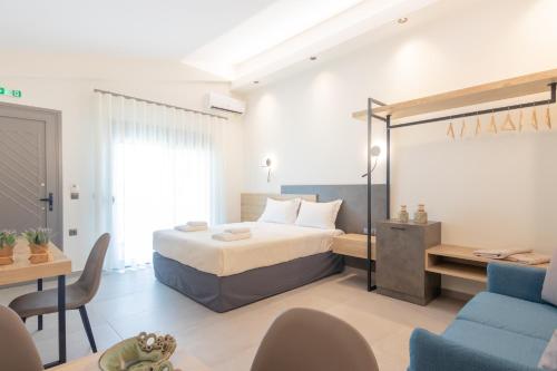 Un dormitorio con una cama, un escritorio y un sofá. en Oli Terra Seaside, en Skala Potamias