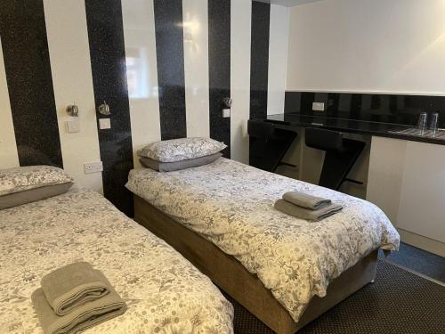 a room with two beds with towels on them at OYO The Bentleys Hotel in Newcastle upon Tyne
