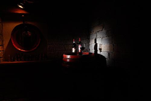two bottles of wine sitting on a barrel in a dark room at Hotel Villa Rina in Bormio