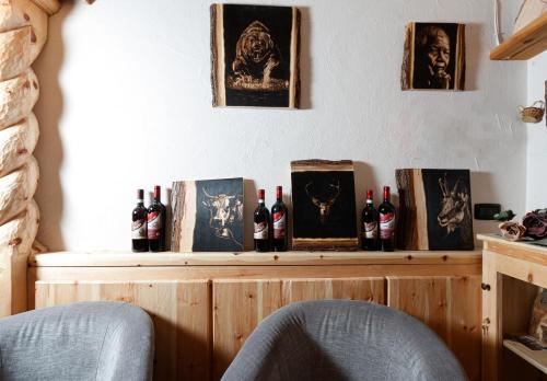 a shelf with bottles of wine on a wall at Hotel Villa Rina in Bormio