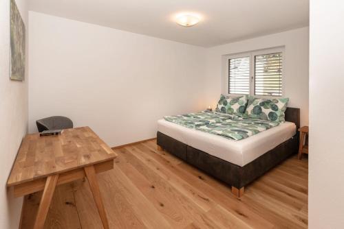a bedroom with a bed and a wooden table at Ferienhaus Reiter Jochberg bei Kitzbühel in Jochberg