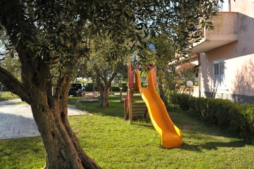 an orange slide in a tree next to a house at Agriturismo San Raphael in Capaccio-Paestum