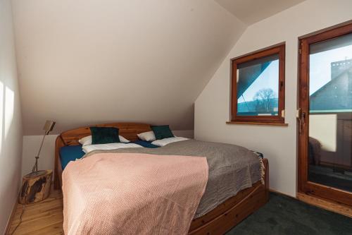 a bedroom with a bed and a window at Pod Śnieżnymi Kotłami in Piechowice