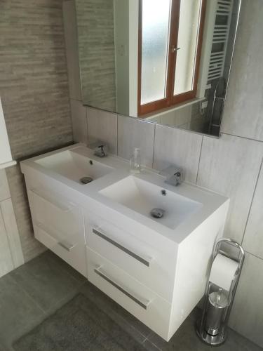 a bathroom with a white sink and a mirror at Bellevue Josselin 1a Chemin des Cruyere in Josselin