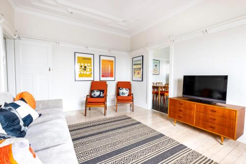 een woonkamer met een bank en een tv bij Chic Bondi Beach Pad in Sydney
