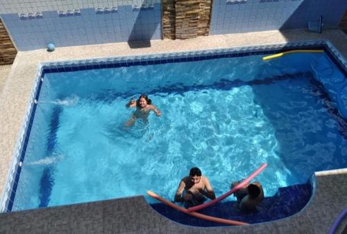 a group of people in a swimming pool with surfboards at Pousada Sossego Salinas in Salinópolis