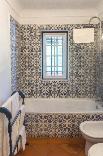 a bathroom with a toilet and a window at Moinho Do Álamo in Montemor-o-Novo