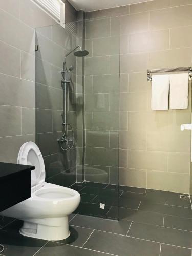 a bathroom with a toilet and a glass shower at BIỂN ĐỒI Bungalow in Phu Quoc