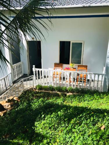 a porch of a house with a table and chairs at BIỂN ĐỒI Bungalow in Phu Quoc