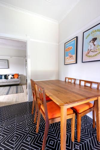 a dining room with a wooden table and chairs at Chic Bondi Beach Pad in Sydney