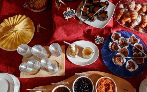 a table topped with plates of food and pastries at Hotel Villa Rina in Bormio