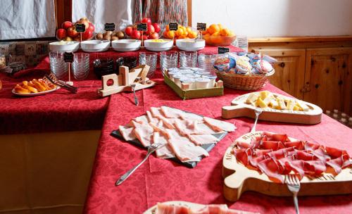 a table with a red table cloth with food on it at Hotel Villa Rina in Bormio