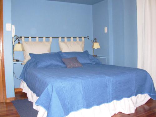 Departamentos de Irene في سالتا: غرفة نوم زرقاء مع سرير كبير بجدران زرقاء
