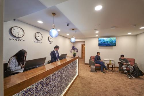 a group of people sitting at a reception desk at Asli Makon Hotel in Tashkent