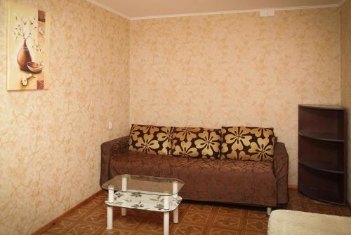 a living room with a brown couch and a table at Pobeda Apartment in Dnipro