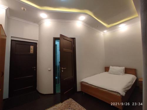 a small bedroom with a bed and a ceiling at Altyn in Astana