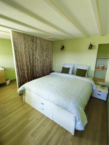 une chambre avec un grand lit dans une pièce dans l'établissement Gîte dans une ambiance végétale avec Spa privatif, à Jazennes