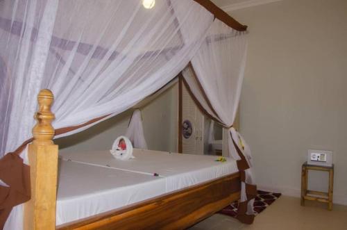 a large bed with a canopy on top of it at Summer Dream Lodge in Paje