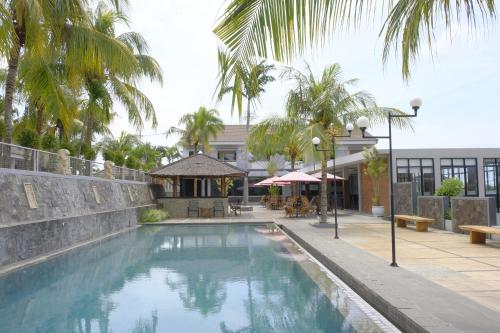 a swimming pool in front of a building at Kuraya Hotel Residence in Bandar Lampung