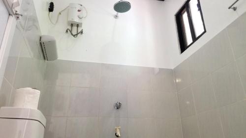 a white bathroom with a toilet and a window at Yayay Siargao in General Luna