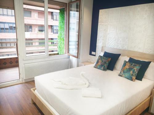 a large white bed in a room with a window at San Antón Piso de lujo centro con Aire ac by Apartamentos Logrono in Logroño