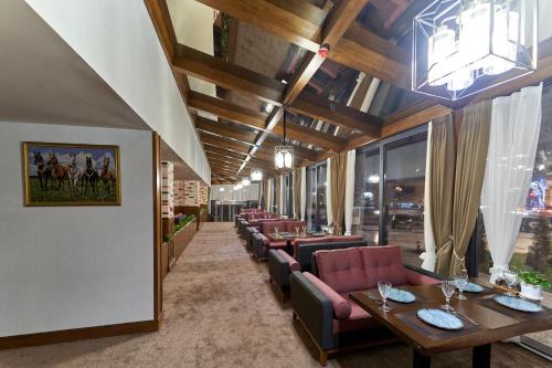 ein Restaurant mit Sofas, Tischen und Stühlen in der Unterkunft Asli Makon Hotel in Taschkent
