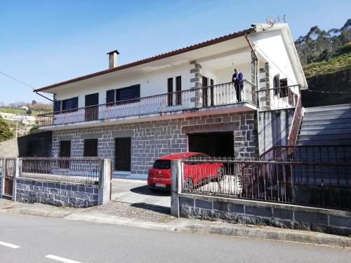 a man standing on the balcony of a house at Parada's House in Paredes de Coura