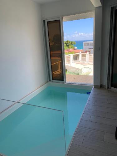a room with a glass floor with a view of the ocean at Le Roof Top in Le Gosier