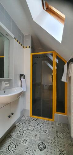 uma casa de banho com um lavatório e uma cabina de duche em vidro. em Chambre double em Boersch