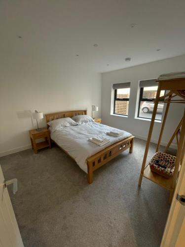 a bedroom with a bed with a ladder and two windows at 10 Argyle Court in Whitby